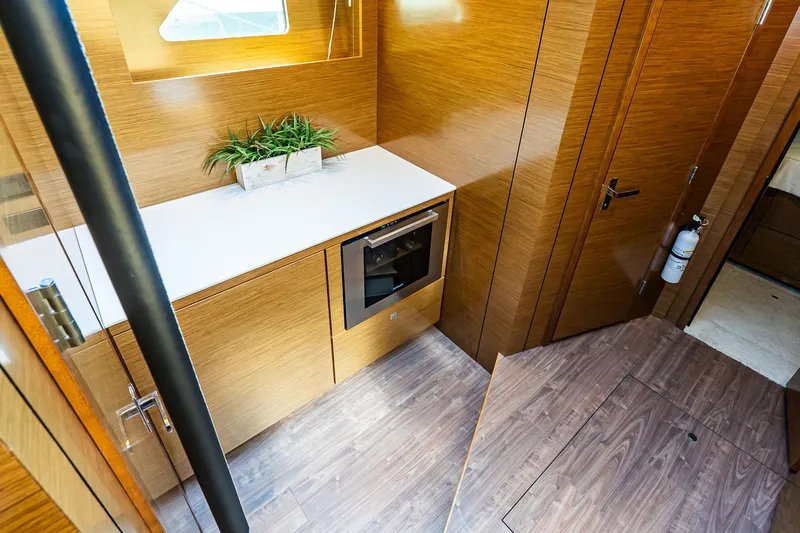 My Way Yacht Photos Pics 2019 Cruisers Yachts 54 Cantius interior with modern wood finish and compact kitchen area.