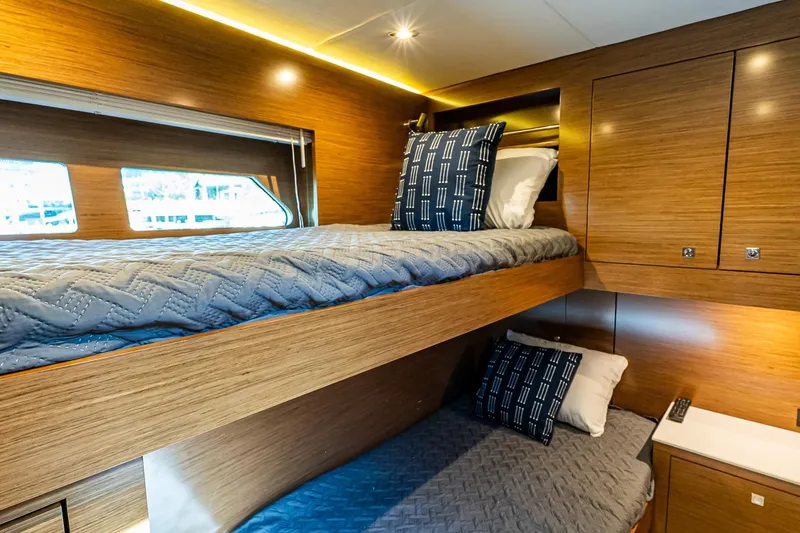 My Way Yacht Photos Pics Luxurious 2019 Cruisers Yachts 54 Cantius cabin with cozy bunk beds and modern wood finish.