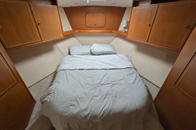  Yacht Photos Pics Cozy bedroom in 2004 Ocean Yachts 50 Super Sport with wooden cabinets and comfortable bedding.