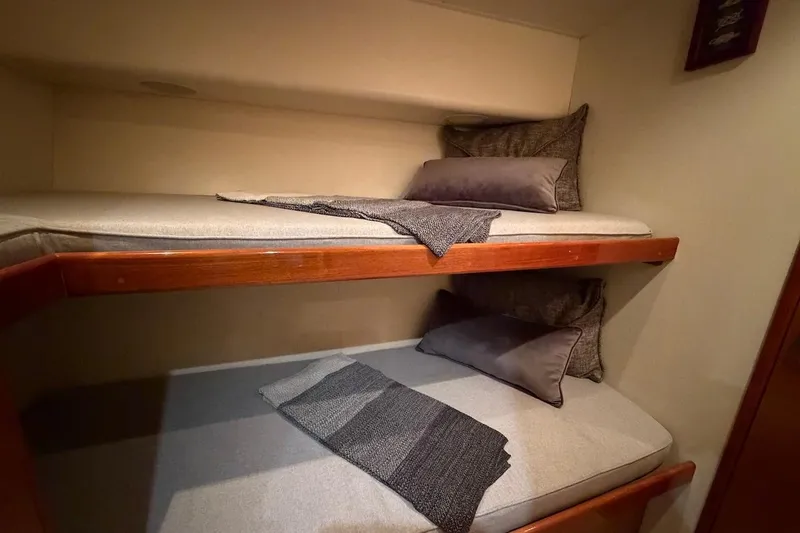 Maritere Yacht Photos Pics Bunk beds in 1999 Viking 58 Convertible yacht cabin, featuring cozy gray bedding.