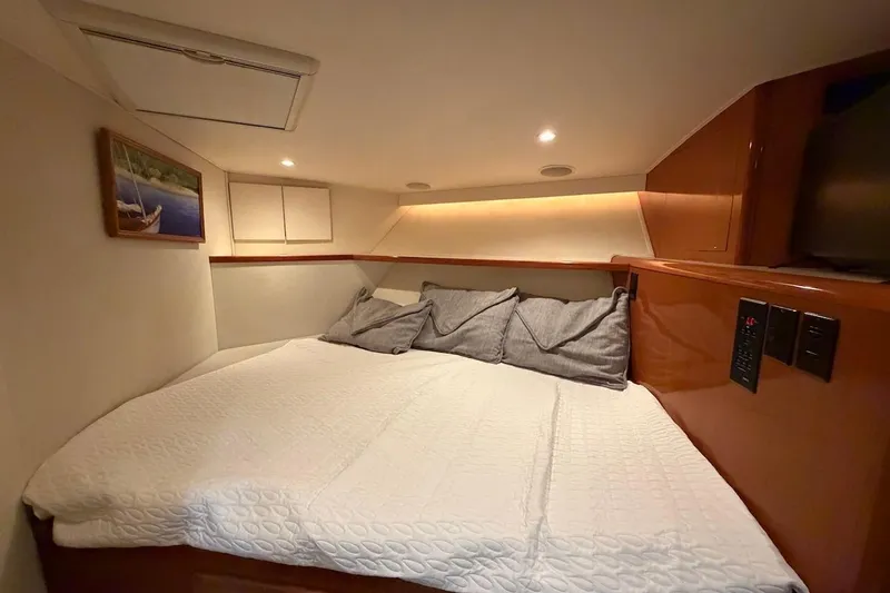 Maritere Yacht Photos Pics Cozy cabin interior of 1999 Viking 58 Convertible yacht with bed and soft lighting.