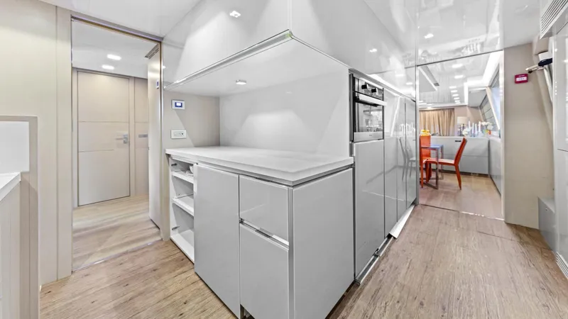 Chitochi Yacht Photos Pics Modern yacht interior with sleek kitchen design, featuring white cabinetry and wood flooring, Custom Line 2016.