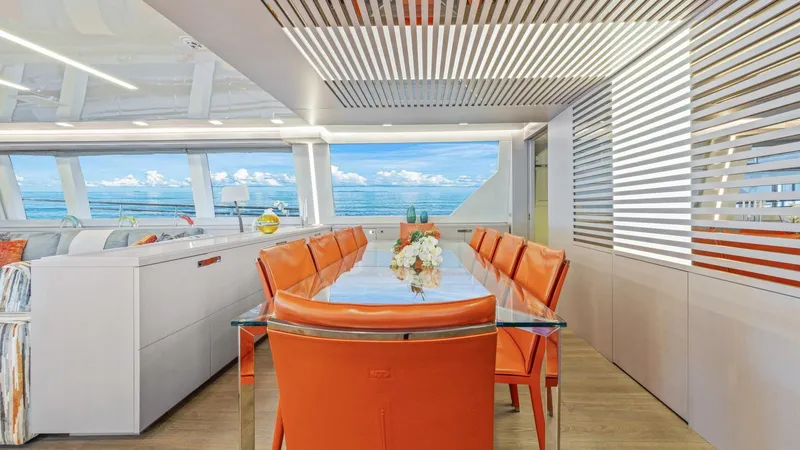 Chitochi Yacht Photos Pics Luxurious yacht interior with orange chairs, glass table, and ocean view, Custom Line Ferretti Group 2016.