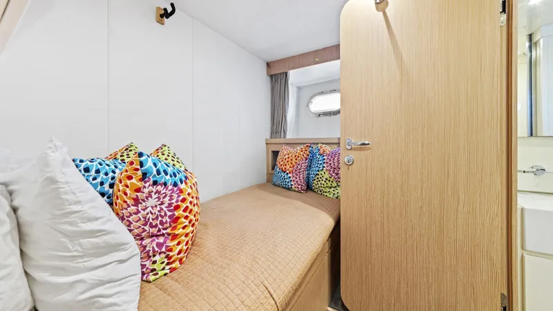 Chitochi Yacht Photos Pics Cozy cabin interior of 2016 Custom Line Ferretti yacht with colorful pillows and wooden door.