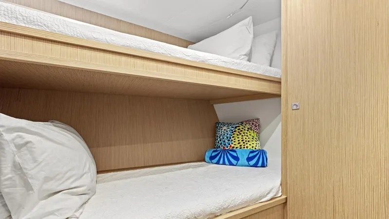 Chitochi Yacht Photos Pics Bunk beds in a 2016 Custom Line Ferretti Group yacht cabin, featuring colorful pillows.