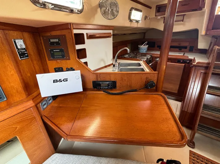 Island Girl Yacht Photos Pics Interior of 1990 Island Packet 38 sailboat with wooden cabinetry and navigation equipment.