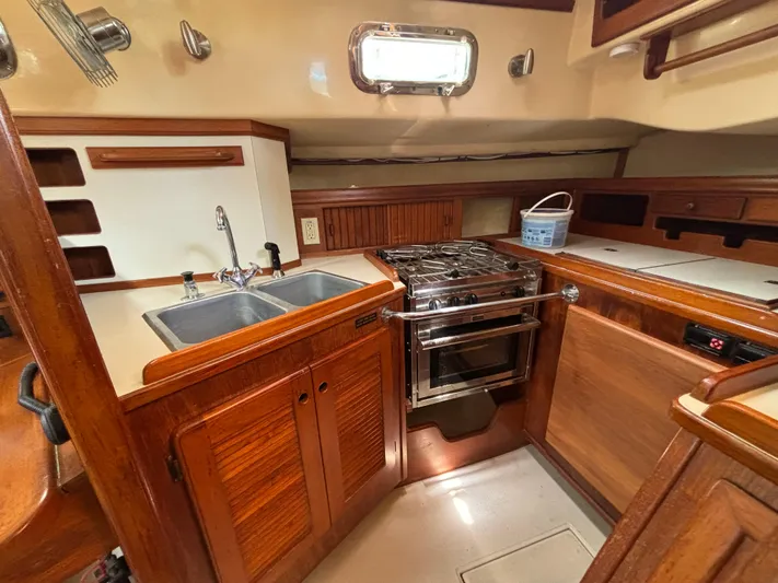 Island Girl Yacht Photos Pics 1990 Island Packet 38 yacht kitchen with wooden cabinetry, dual sink, and stainless steel stove.