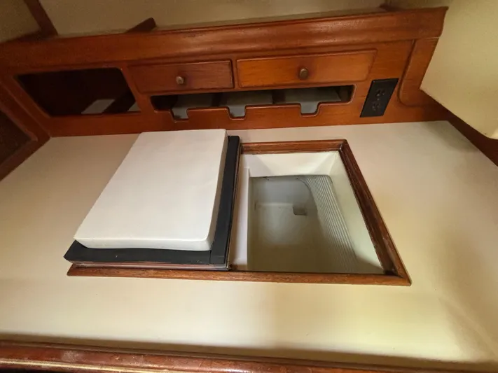 Island Girl Yacht Photos Pics Interior of 1990 Island Packet 38 sailboat showing storage compartment and wooden cabinetry.