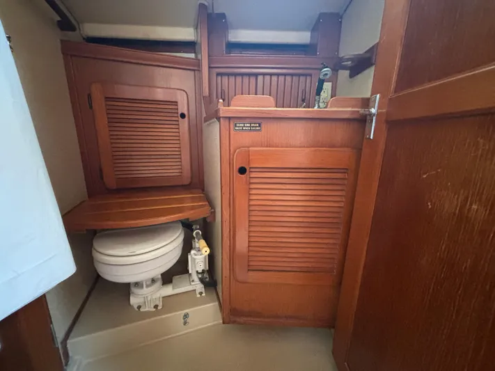 Island Girl Yacht Photos Pics 1990 Island Packet 38 sailboat bathroom with wooden cabinetry and marine toilet.
