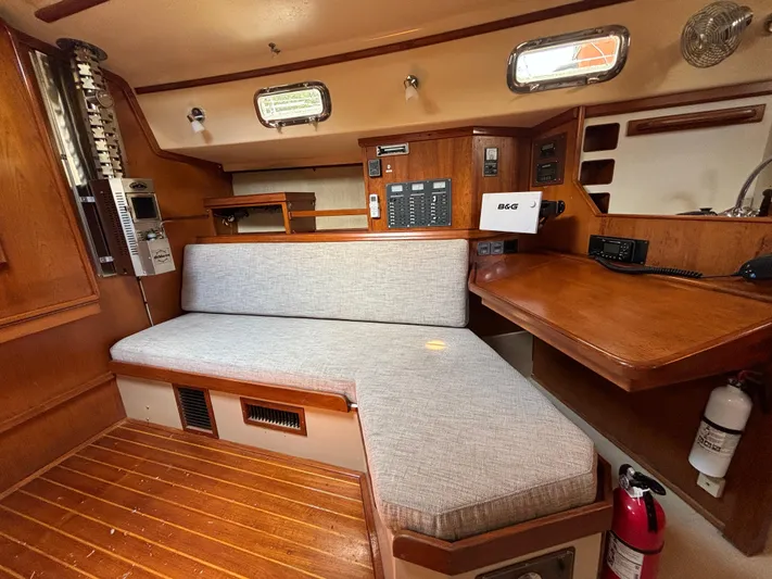 Island Girl Yacht Photos Pics Interior of 1990 Island Packet 38 sailboat with wooden furnishings and cushioned seating.