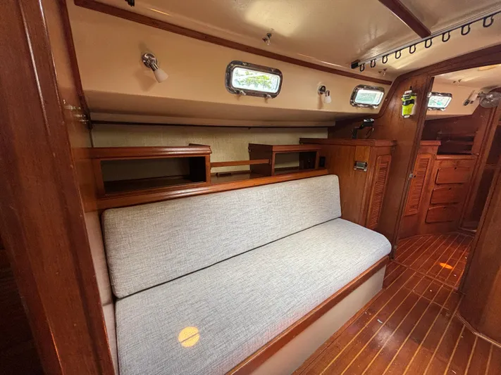 Island Girl Yacht Photos Pics 1990 Island Packet 38 interior with wooden finish and cushioned seating.