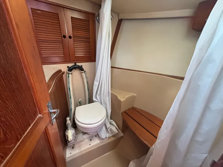 Island Girl Yacht Photos Pics 1990 Island Packet 38 sailboat bathroom with wooden accents and shower curtain.