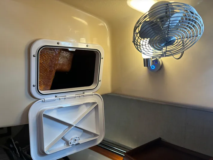 Island Girl Yacht Photos Pics 1990 Island Packet 38 cabin interior with open porthole and wall-mounted fan.