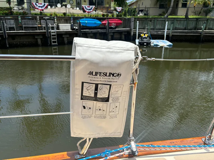 Island Girl Yacht Photos Pics Lifesling on 1990 Island Packet 38 sailboat, docked by a calm waterfront.