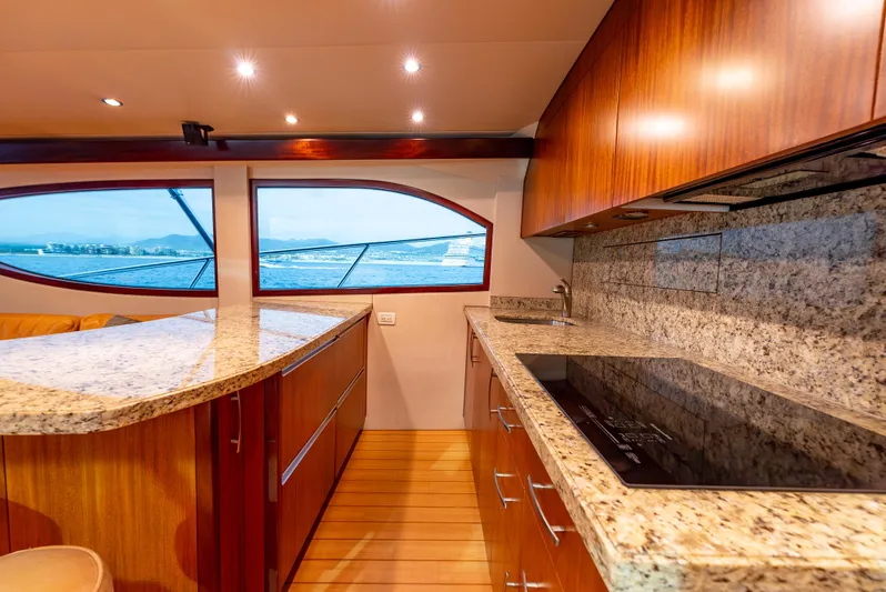 Baja Vida Yacht Photos Pics Luxurious kitchen interior of 2010 Hatteras 60 Convertible yacht with granite countertops and ocean view.