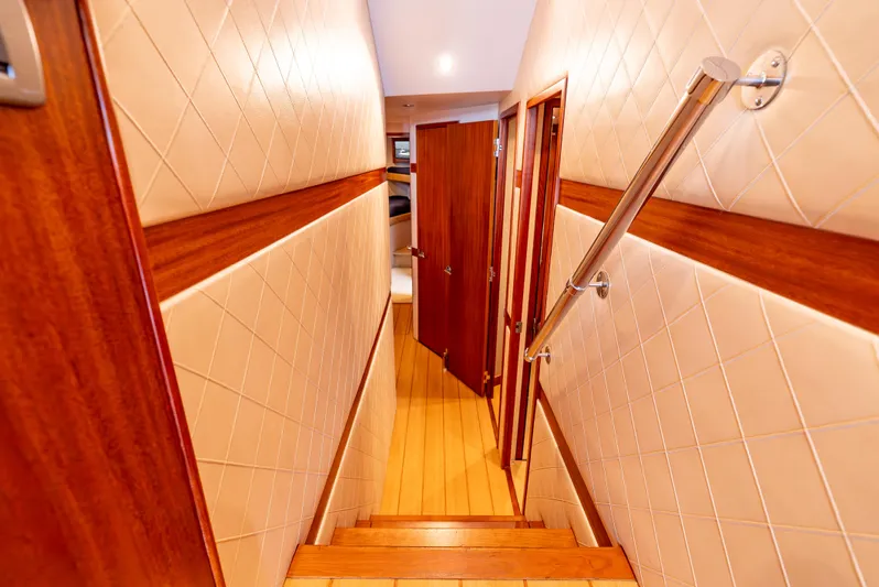 Baja Vida Yacht Photos Pics Interior hallway of 2010 Hatteras 60 Convertible yacht with wooden doors and handrail.
