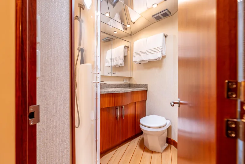 Baja Vida Yacht Photos Pics Luxurious bathroom in 2010 Hatteras 60 Convertible yacht with modern fixtures and wooden accents.