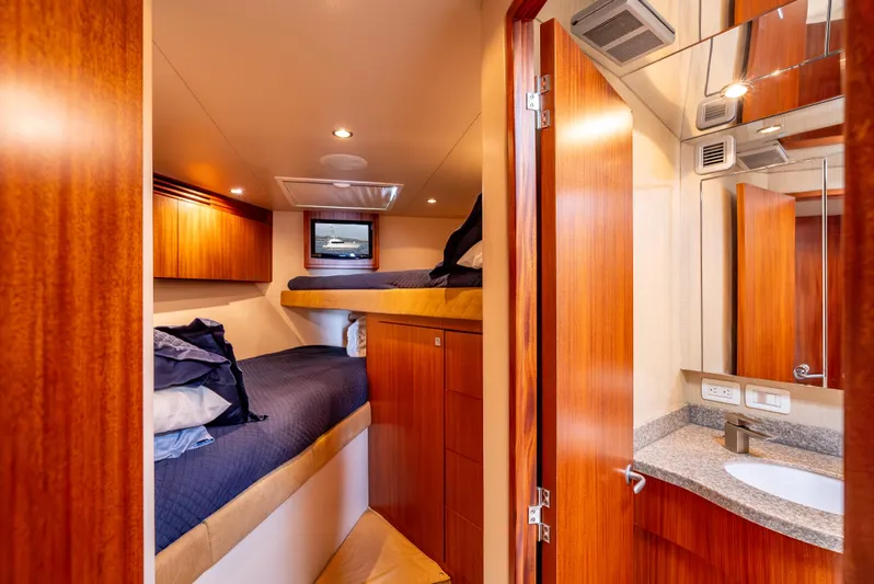 Baja Vida Yacht Photos Pics Interior of 2010 Hatteras 60 Convertible yacht with cozy bunk beds and wooden cabinetry.