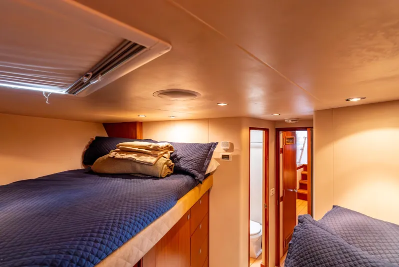 Baja Vida Yacht Photos Pics Interior of 2010 Hatteras 60 Convertible yacht with cozy bunk beds and warm lighting.