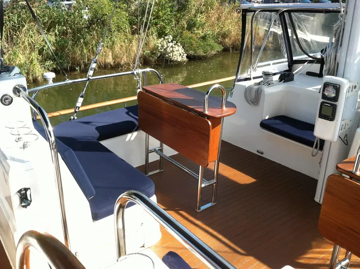 The Harlen Wood Yacht Photos Pics Cockpit of 2010 Shannon 53 HPS yacht with wooden seating and blue cushions.