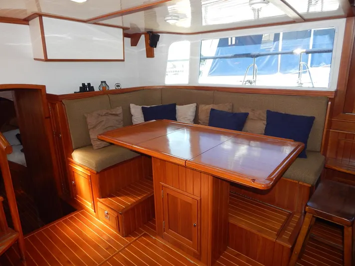 The Harlen Wood Yacht Photos Pics Luxurious interior of 2010 Shannon 53 HPS yacht with wooden dining area and cushioned seating.