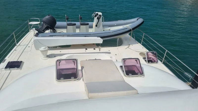 Albatross Yacht Photos Pics 2014 PowerPlay Catamarans Power Cat with dinghy on deck, anchored in clear blue water.