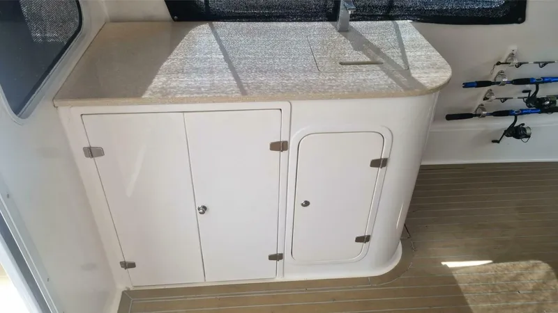 Albatross Yacht Photos Pics 2014 PowerPlay Catamarans Power Cat interior with storage cabinets and fishing rods.