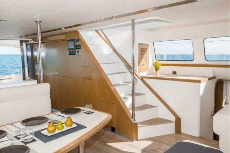 Albatross Yacht Photos Pics Luxurious 2014 PowerPlay Catamarans Power Cat interior with dining area and staircase.