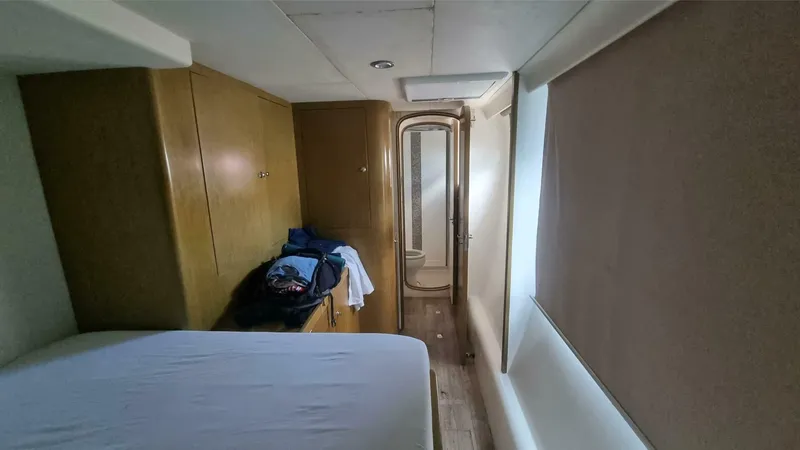 Albatross Yacht Photos Pics 2014 PowerPlay Catamarans Power Cat cabin interior with bed and wooden cabinetry.