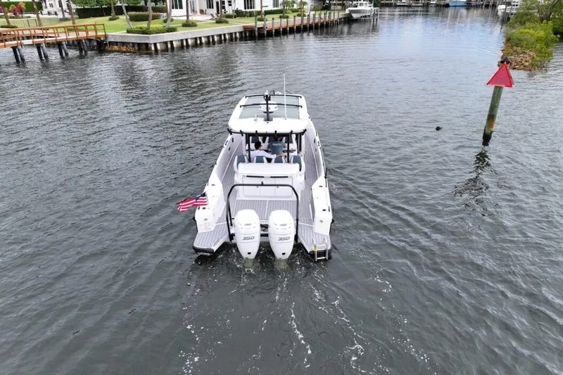  Yacht Photos Pics 2022 Axopar 37 Sun-Top boat cruising on a calm waterway.