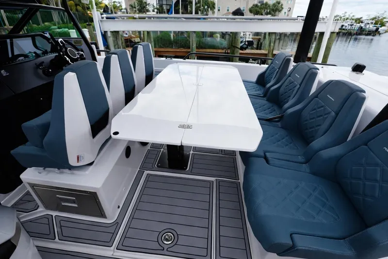  Yacht Photos Pics 2022 Axopar 37 Sun-Top boat interior with blue seating and white table.