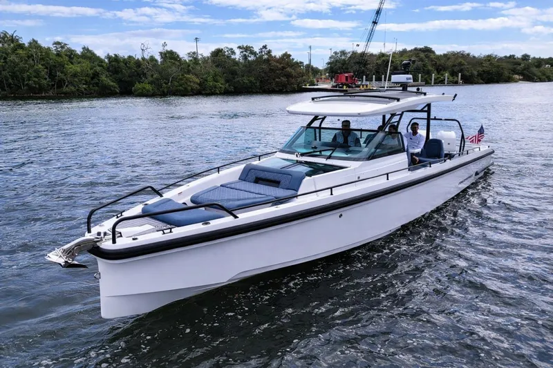  Yacht Photos Pics 2022 Axopar 37 Sun-Top boat cruising on a scenic waterway.