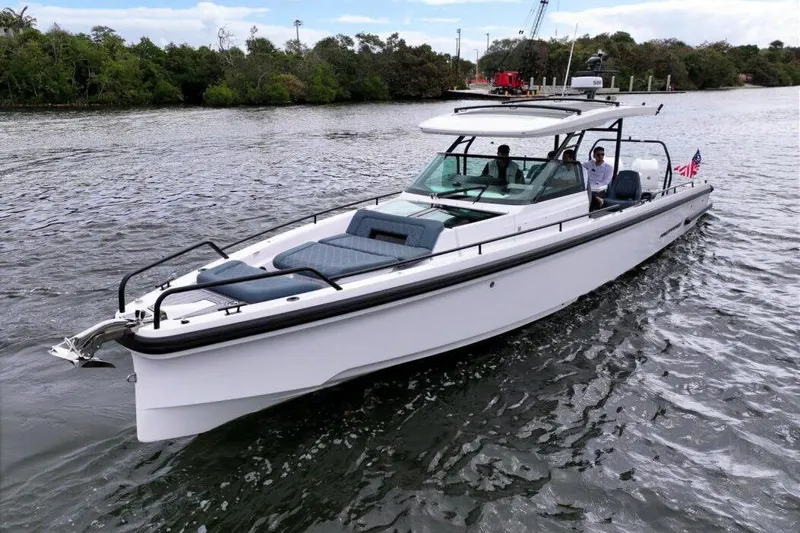  Yacht Photos Pics 2022 Axopar 37 Sun-Top boat cruising on a scenic waterway.