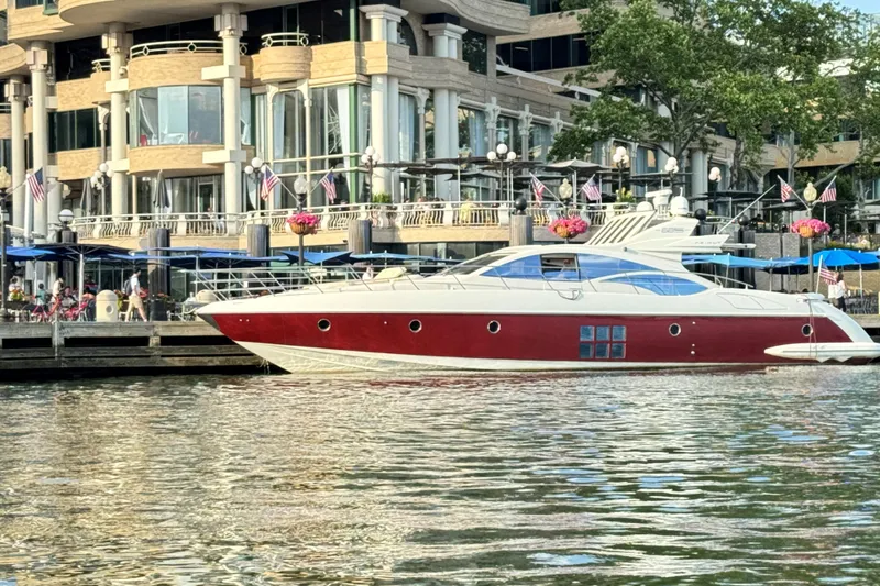 Victoria Yacht Photos Pics 2007 Azimut 68S yacht docked near a waterfront building with flags and flowers.