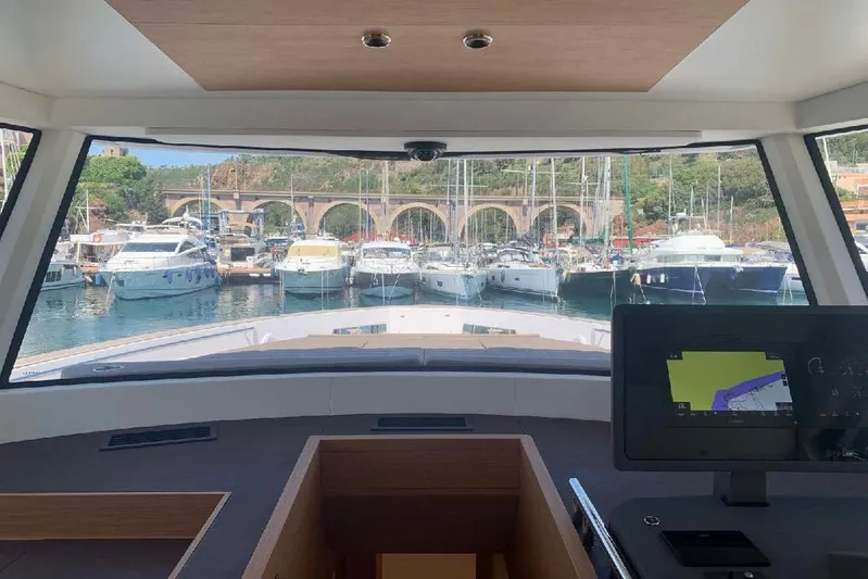 Pardo Endurance 60 Yacht Photos Pics Interior view from 2023 Pardo Yachts E60, overlooking marina with multiple boats and scenic bridge.