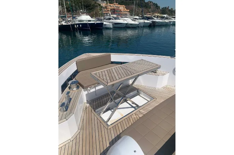 Pardo Endurance 60 Yacht Photos Pics 2023 Pardo Yachts E60 deck with seating and adjustable table in marina.