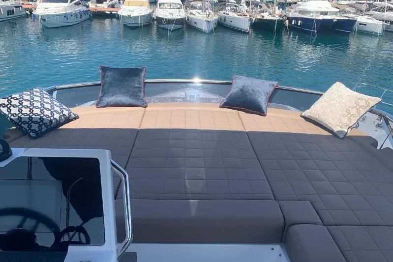 Pardo Endurance 60 Yacht Photos Pics Luxurious 2023 Pardo Yachts E60 with sunbathing deck and cushions, docked in a marina.