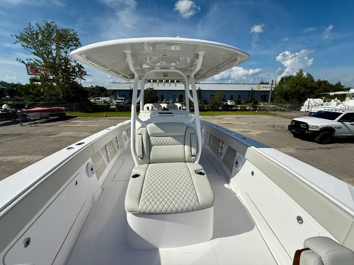  Yacht Photos Pics 2026 Jupiter 34 boat with sleek seating and canopy, parked outdoors under a blue sky.