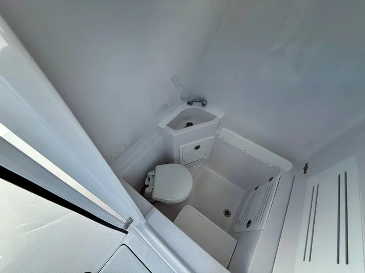  Yacht Photos Pics Compact bathroom in 2026 Jupiter 34 model, featuring a toilet and sink.