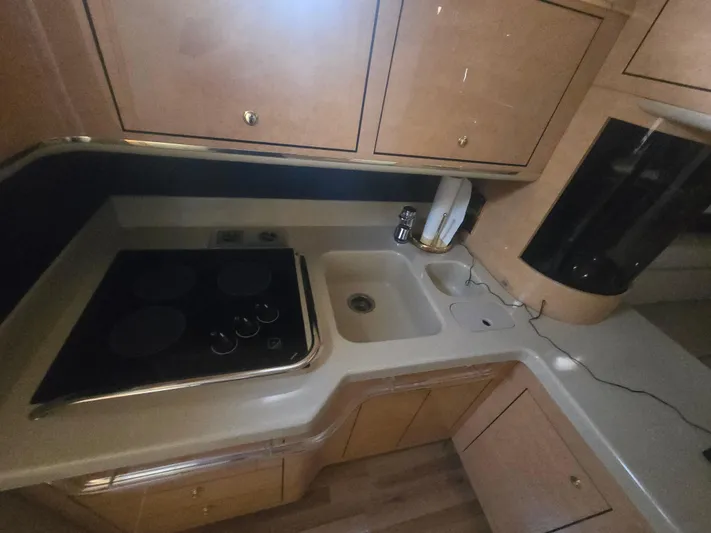 Michael B Yacht Photos Pics 1998 Sea Ray 500 Sundancer kitchen with stove, sink, and wooden cabinets.