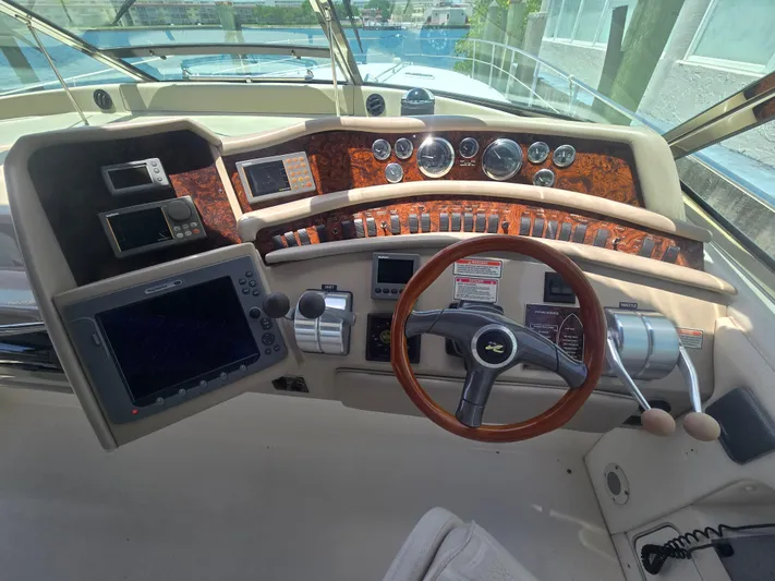 Michael B Yacht Photos Pics 1998 Sea Ray 500 Sundancer helm with wood accents and modern navigation equipment.