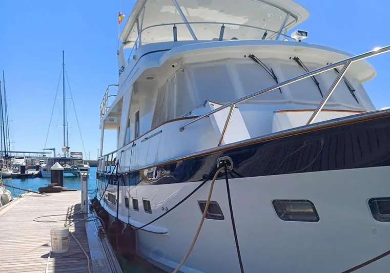 Bochinche Yacht Photos Pics 2006 Grand Alaskan 65 Flush Deck yacht docked at marina under clear blue sky.
