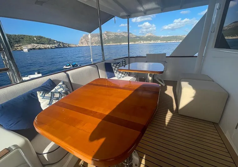 Bochinche Yacht Photos Pics Luxurious 2006 Grand Alaskan 65 Flush Deck yacht with elegant outdoor seating and scenic ocean view.