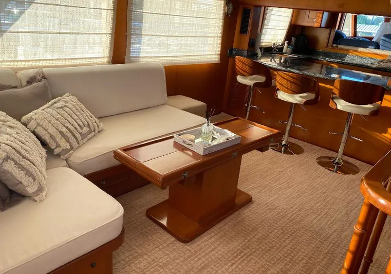 Bochinche Yacht Photos Pics Luxurious interior of 2006 Grand Alaskan 65 Flush Deck yacht with cozy seating and bar area.