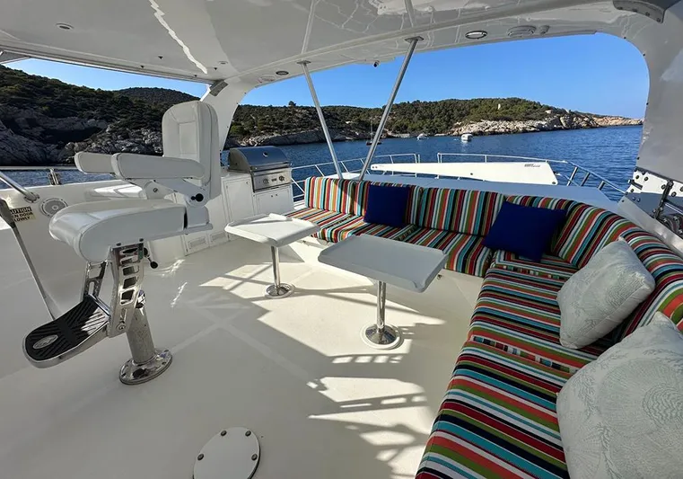 Bochinche Yacht Photos Pics Luxurious 2006 Grand Alaskan 65 Flush Deck yacht with colorful seating and scenic ocean view.