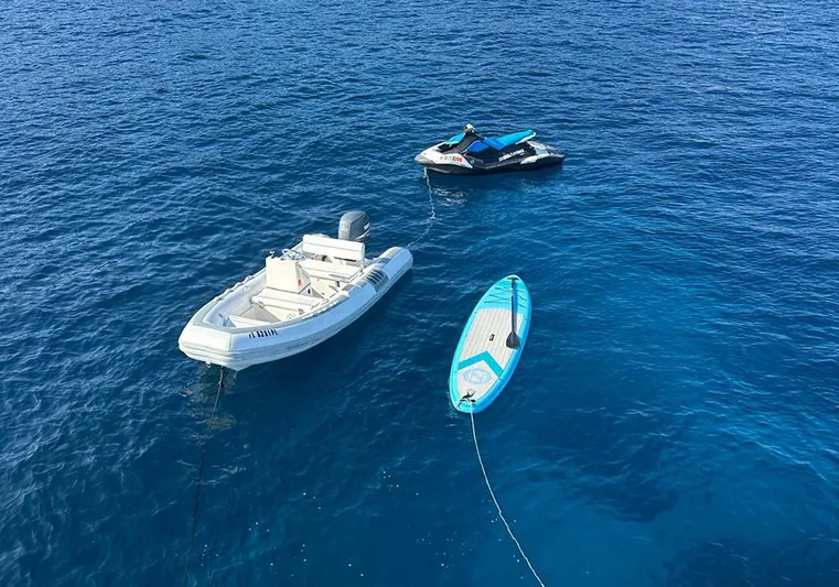 Bochinche Yacht Photos Pics Boats and paddleboard floating on clear blue water, near a 2006 Grand Alaskan 65 Flush Deck.