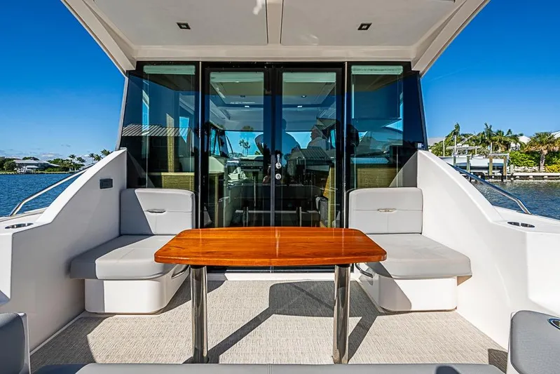 Polaris Yacht Photos Pics 2018 Tiara Yachts C39 Coupe, elegant outdoor seating with wooden table, scenic waterfront view.