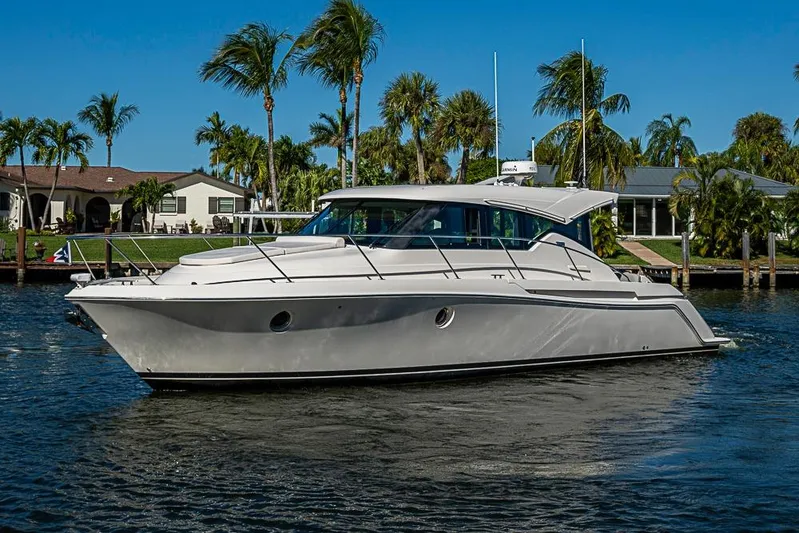 Polaris Yacht Photos Pics 2018 Tiara Yachts C39 Coupe cruising on a sunny day near palm-lined waterfront homes.