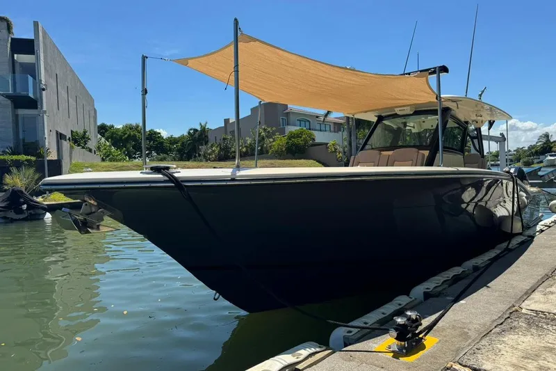  Yacht Photos Pics 2020 Scout 355 LXF boat docked with sunshade, modern waterfront setting.