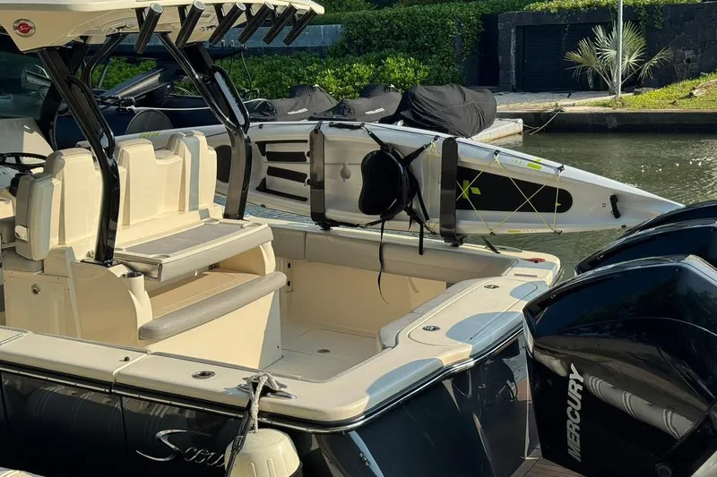  Yacht Photos Pics 2020 Scout 355 LXF boat with paddleboard, docked by water, featuring Mercury engines.